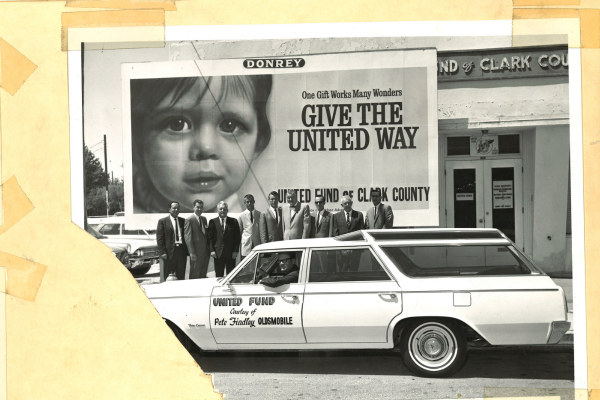 Vintage black and white photo of United Way staff behind white Findlay Honda car in front of "give the united way" advertisement.