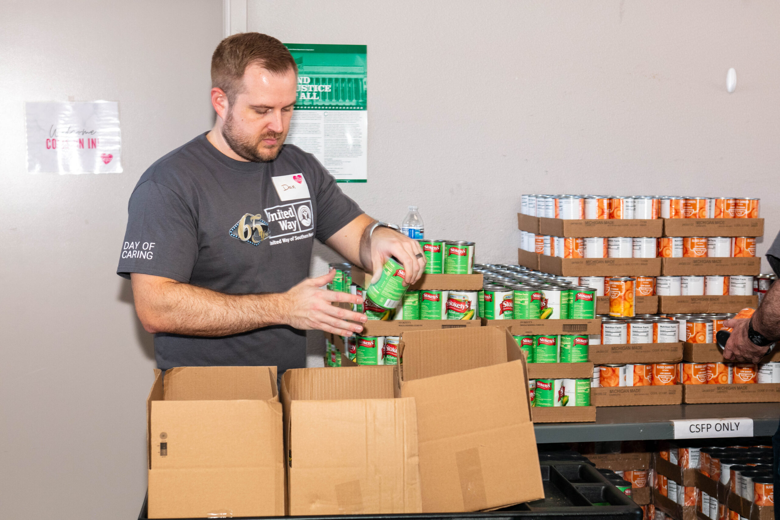 Volunteer packing canned food in boxes.