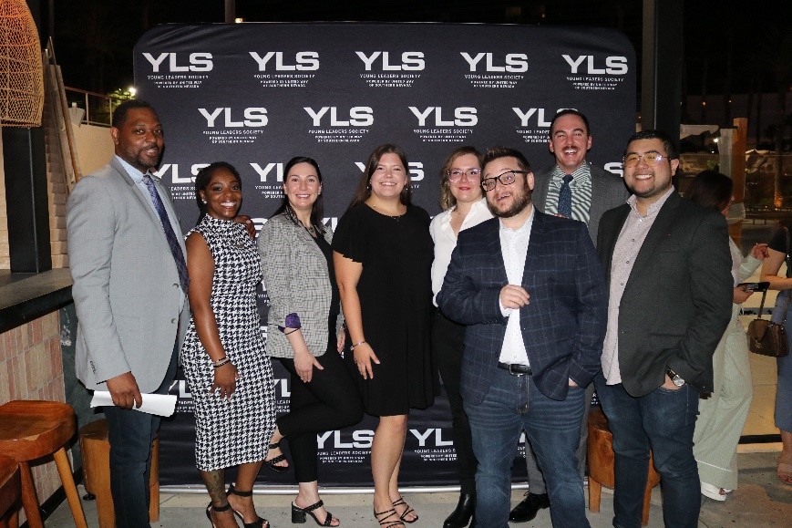 YLS members standing in front of a YLS backdrop at Kassi Beach House