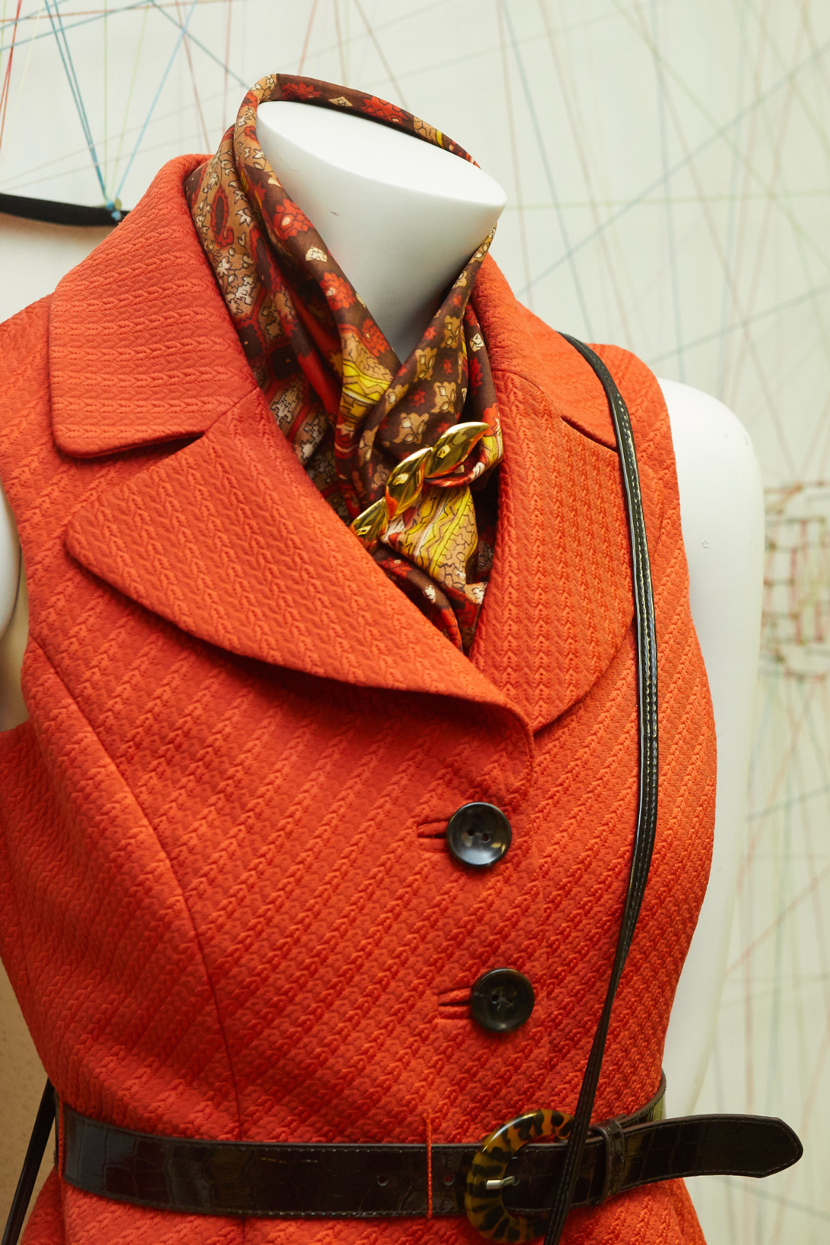 mannequin with an orange vest and orange neck scarf