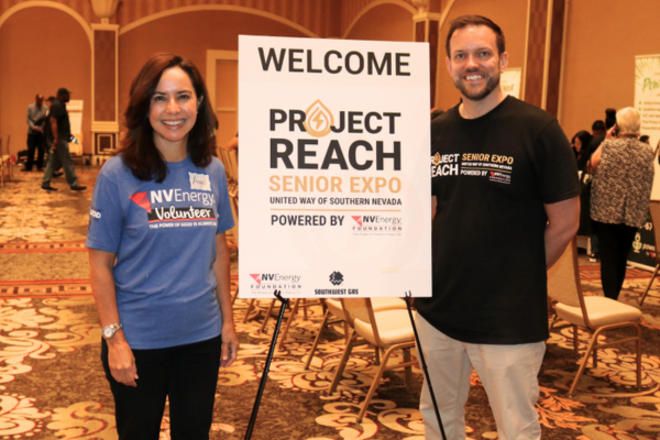 Project REACH Leaders posing in front of a project reach sign and smiling for the camera