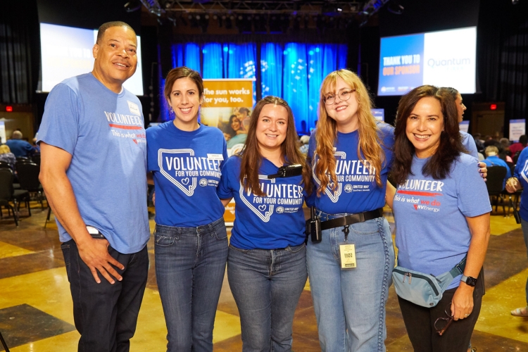 five people standing in a line smiling